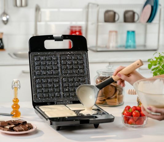 Z gofrownicy czy z frytkownicy? Poznaj nasze sposoby na desery przygotowywane przy użyciu tych urządzeń Kobieta nalewająca ciasto do gofrownicy