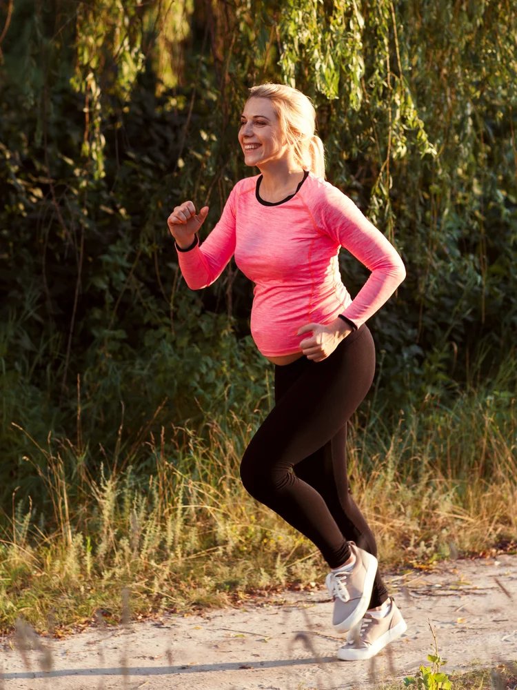 kobieta biegnąca w ciąży z dzieckiem