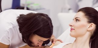 Dermatolog – z czym się udać do tego specjalisty? dermatolog bada skore pacjenta za pomoca dermatoskopu