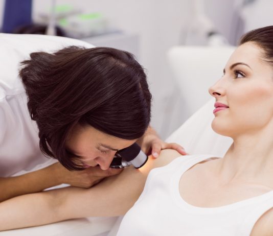 Dermatolog – z czym się udać do tego specjalisty? dermatolog bada skore pacjenta za pomoca dermatoskopu