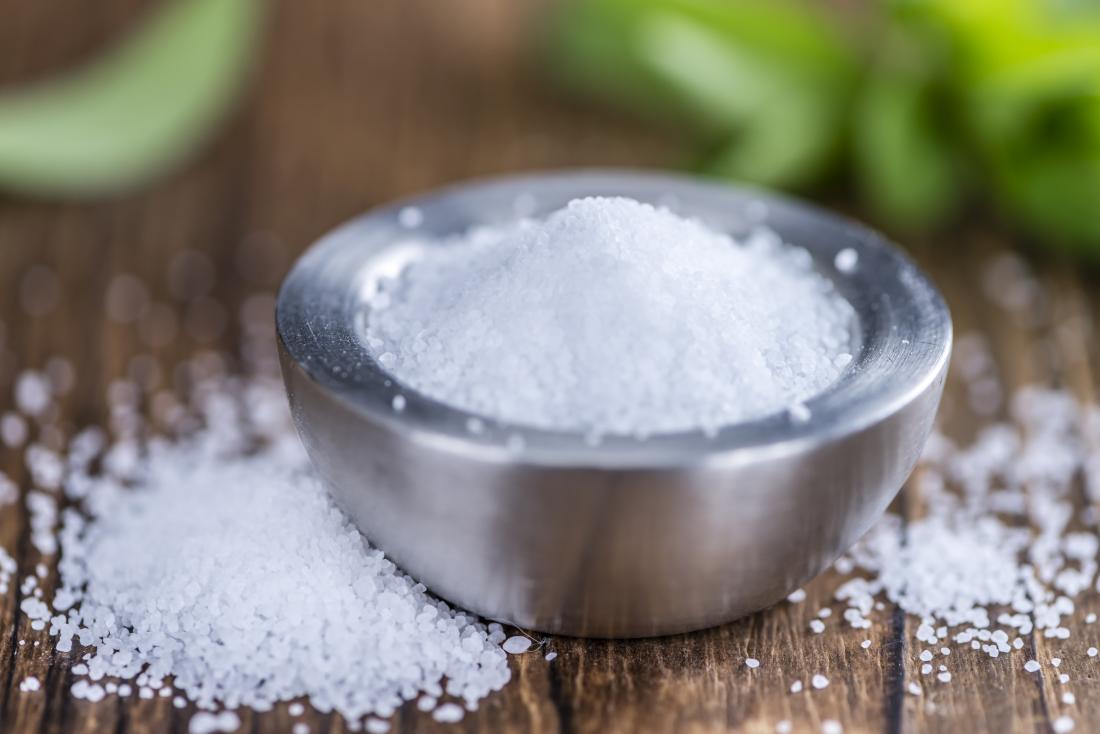 Zielone kulki z daktyli obtoczone wiórkami kokosowymi na białym talerzu