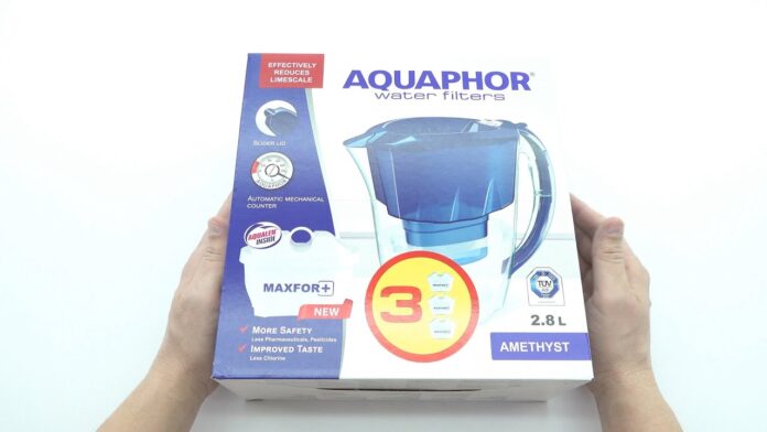 Dwa dzbanki filtrujące Aquaphor Crystal i Brita obok zanieczyszczonej i czystej wody