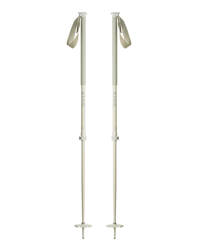 Początkujący narciarz z kijami Atomic i Salomon na zaśnieżonym stoku górskim w słońcu