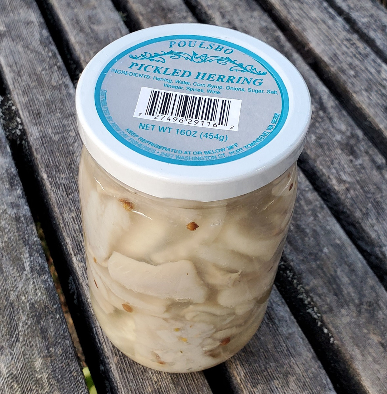 kobieta jedząca widelec z marynowanym śledziem z cebulą przy stole