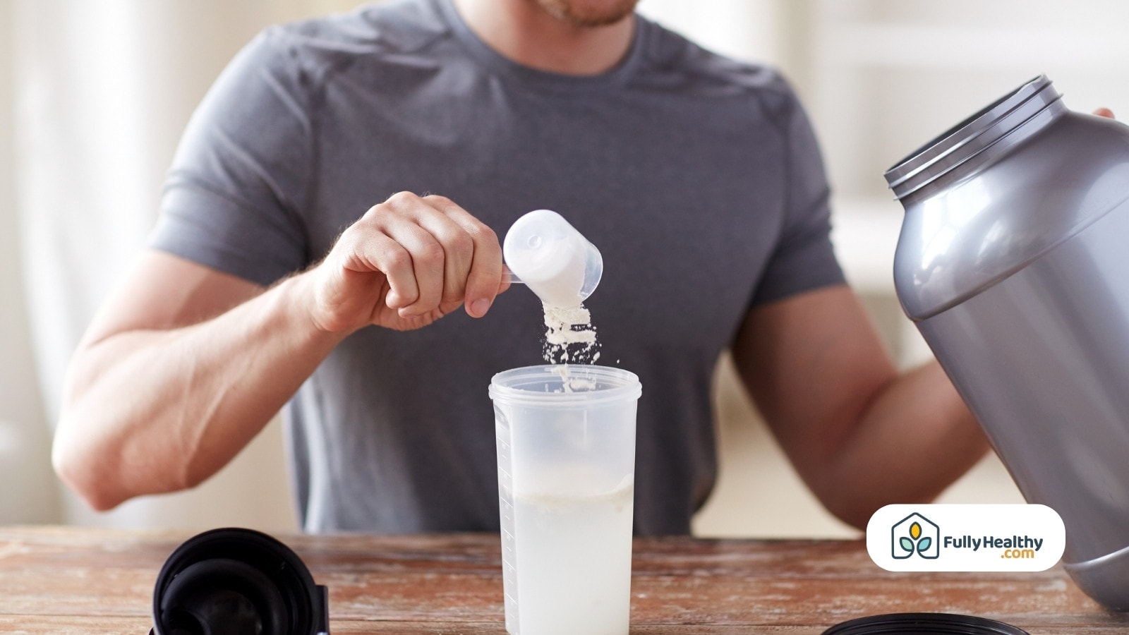 Tauryna w proszku obok puszki energetyka i pulsometru sportowego