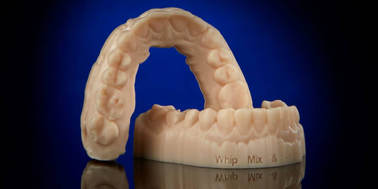 Wydrukowana korona zęba z drukarki 3D Technik wyjmujący świeżo wydrukowaną koronę zęba z platformy drukarki 3D