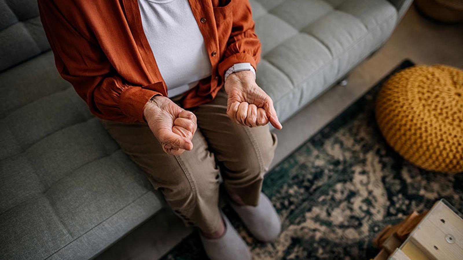 rozciąganie palców dla nadgarstków mężczyzna wykonujący ćwiczenie rozciągające palce i nadgarstek siedząc przy stole