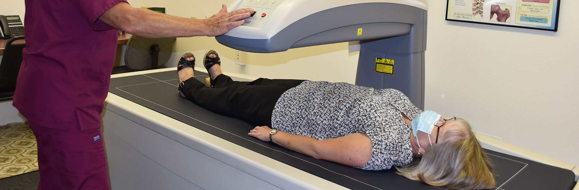 ręka pacjentki umieszczona w specjalnym uchwycie pod skanerem DEXA