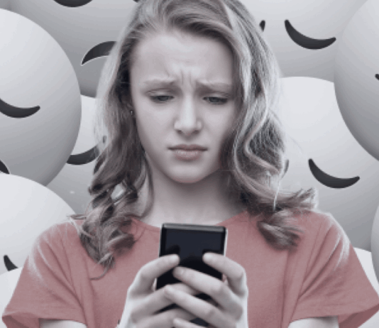 Lajki, komentarze, filtry – jak cyfrowe odbicia zniekształcają obraz, który masz o sobie? młoda kobieta scrollująca telefon z smutną miną na twarzy w sypialni