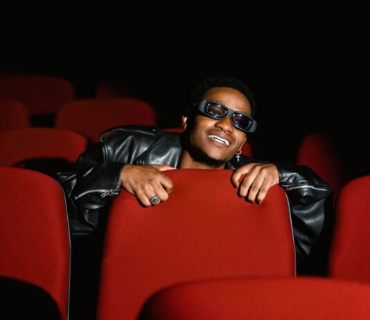 Dopamina, nagroda, powtórzenie – jak pętla uzależnienia przejmuje kontrolę nad Twoim mózgiem? młody mężczyzna wpatrzony w ekran smartfona ignorujący otoczenie w pokoju