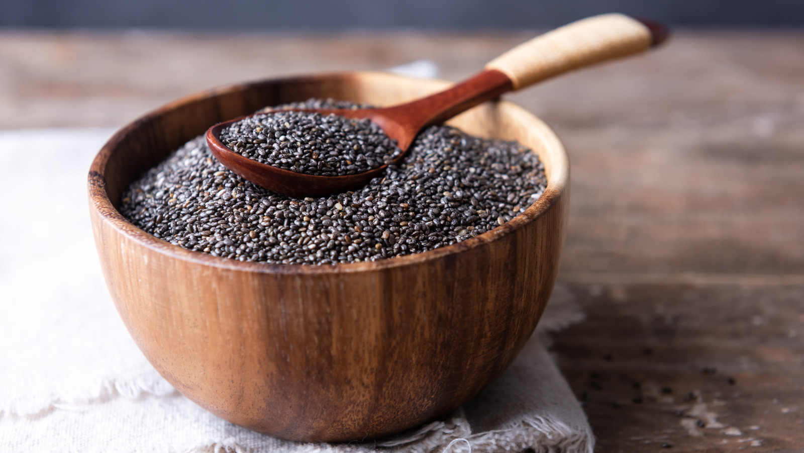 ręce mieszające widelcem nasiona chia w szklance z wodą