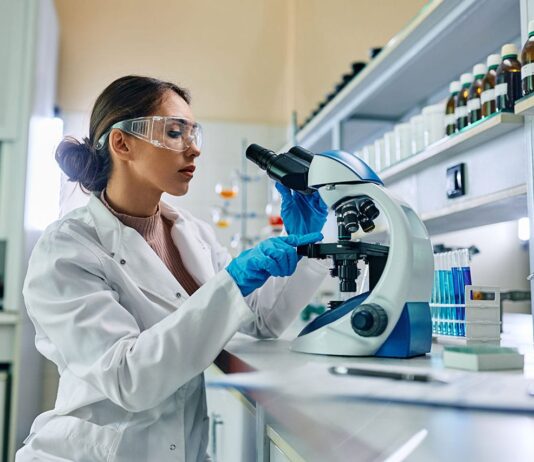 Badania genetyczne w profilaktyce: które testy naprawdę pomagają wykryć zagrożenia, zanim pojawią się objawy? naukowiec w białym kitlu analizujący próbkę DNA pod mikroskopem w laboratorium