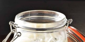 Śledzie w occie – czy ta powszechna przekąska naprawdę zasługuje na miano zdrowej żywności? talerz z marynowanymi śledziami w occie, cebulą i ziołami na drewnianym stole