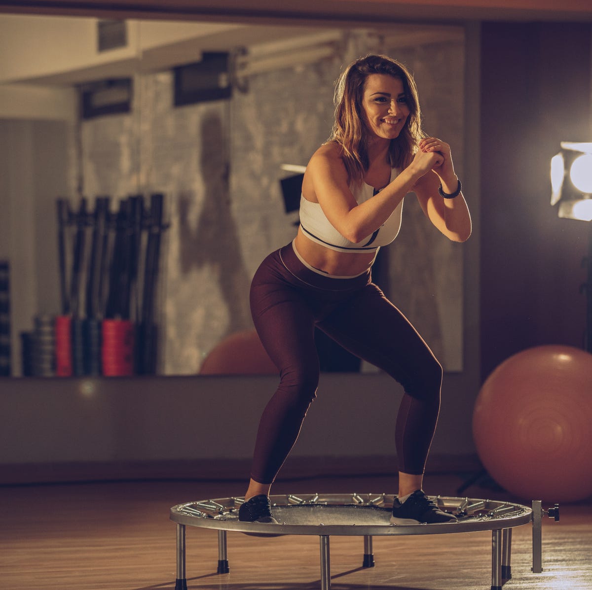 Pewna postawa na sprężystym podłożu Osoba utrzymuje równowagę na niewielkiej trampolinie, stojąc stabilnie na środku