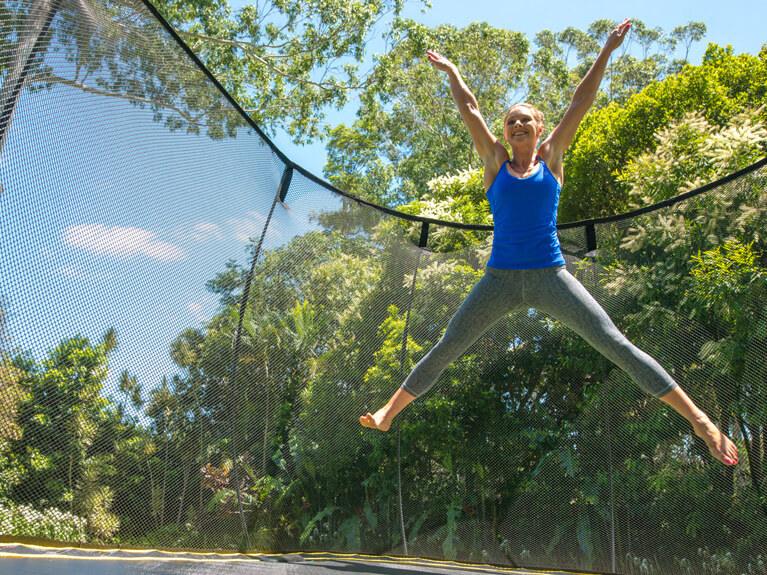 Technika ruchu w sali treningowej Uczestniczka fitness wybija się nad trampoliną, zachowując wyprostowaną sylwetkę
