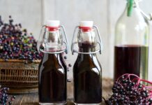 Syrop z czarnego bzu: składniki aktywne, właściwości i bezpieczeństwo Butelka syropu z czarnego bzu na jasnym tle
