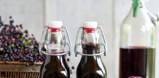 Syrop z czarnego bzu: składniki aktywne, właściwości i bezpieczeństwo Butelka syropu z czarnego bzu na jasnym tle